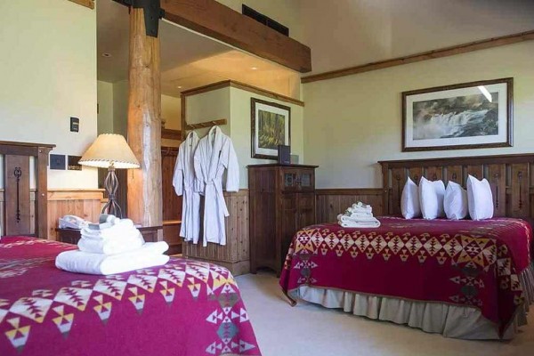 [Image: Luxurious Deluxe Suites Located Within Two Storey Log Cabins with River Views. Wood Burning Fireplace and Private Patio]